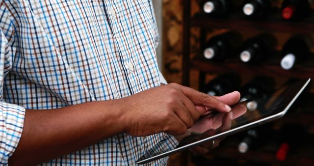 Man Using Tablet in Wine Cellar for Inventory Management - Download Free Stock Images Pikwizard.com