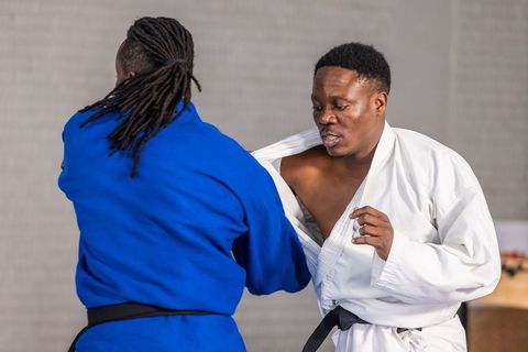 Martial artists sparring in dojo wearing traditional gis
