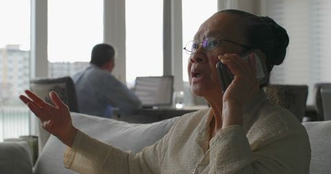 Senior Asian Woman Engaged in Mobile Call at Home