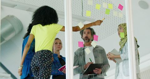 Diverse team collaborating on creative project with sticky notes