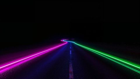 Stretching Neon Road Curving Toward Horizon at Night with Magenta and Green Light Trails