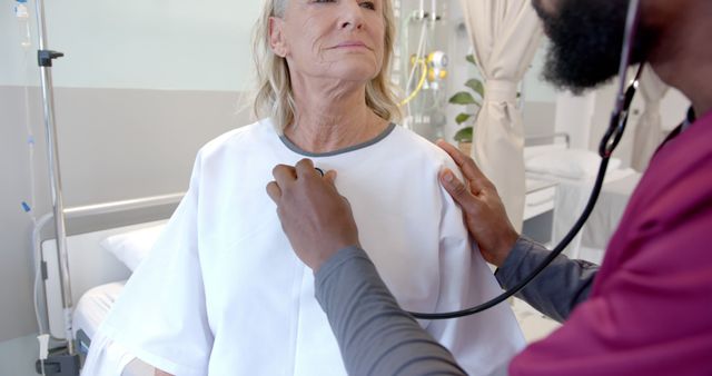 Senior woman receiving a medical examination by male doctor using a stethoscope in a hospital room. Can be used for healthcare advertisements, medical blogs, senior care articles, and hospital website imagery.