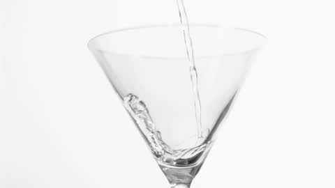 Fresh Vodka Pouring Into Martini Glass in Slow Motion