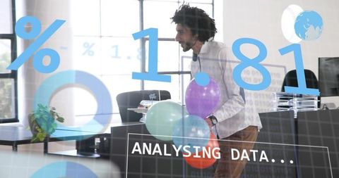 Male analyst carrying balloons leaning at modern office desk with data analytics overlays
