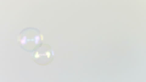 Floating Soap Bubbles Against White Background in Slow Motion