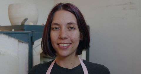 Smiling Female Potter in Workshop Embracing Craft