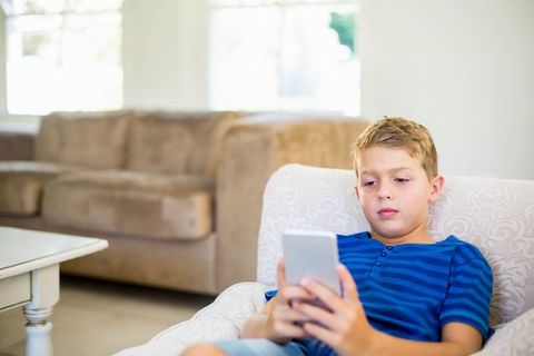 Boy Relaxing with Smartphone in Casual Living Room Atmosphere