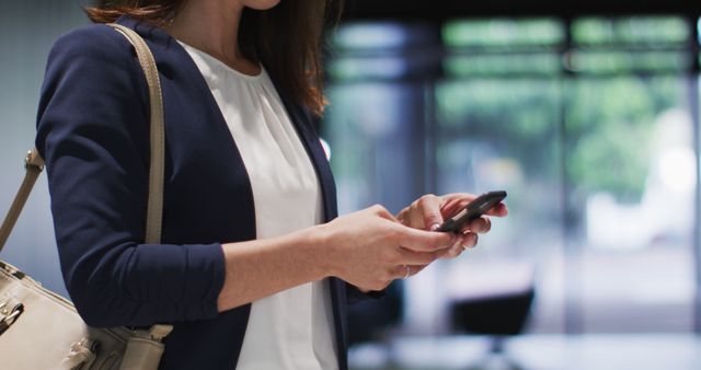 Businesswoman Using Smartphone in Modern Office Entrance - Download Free Stock Images Pikwizard.com