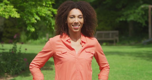 Confident Young Woman in Bright Orange Shirt Relaxing Outdoors - Download Free Stock Images Pikwizard.com