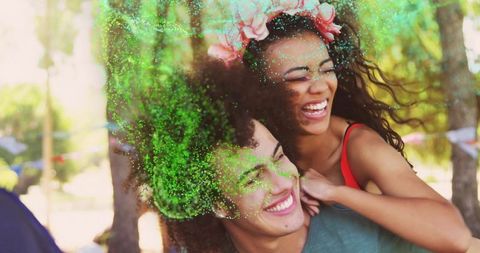 Joyful couple celebrating with green powder at outdoor festival
