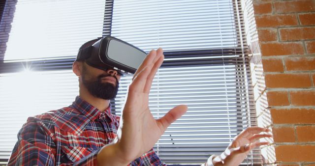 Man Engages With Virtual Reality Experience in Sunlit Office - Download Free Stock Images Pikwizard.com