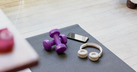 Home workout area with dumbbells and smartphone on yoga mat