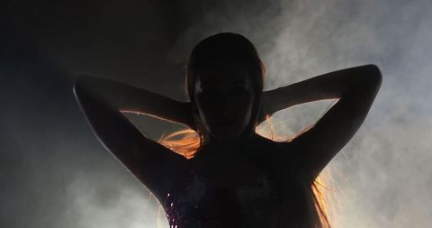 Silhouette of woman dancer backlit with dramatic background