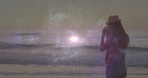 Woman in Hat Capturing Cosmic Light by Ocean at Twilight