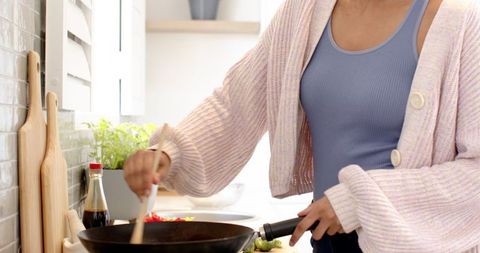 Woman cooking vegetables in modern home kitchen
