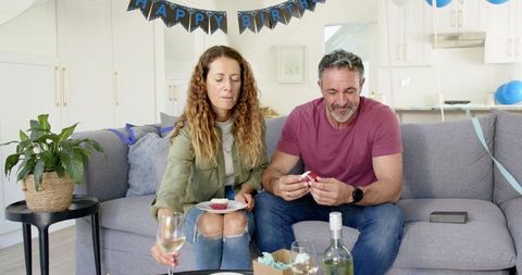 Mature Couple Enjoying Birthday Cupcakes on Cozy Sofa