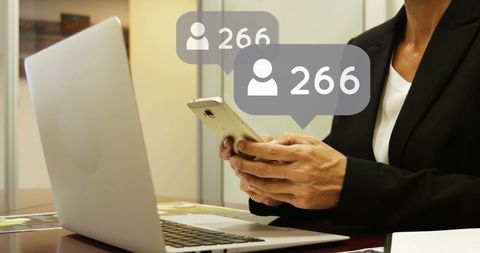 Businesswoman Managing Contacts on Smartphone and Laptop