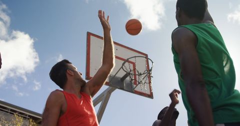 Basketball players practicing outdoors under clear sky