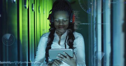 Woman in server room using tablet with futuristic holographic interfaces