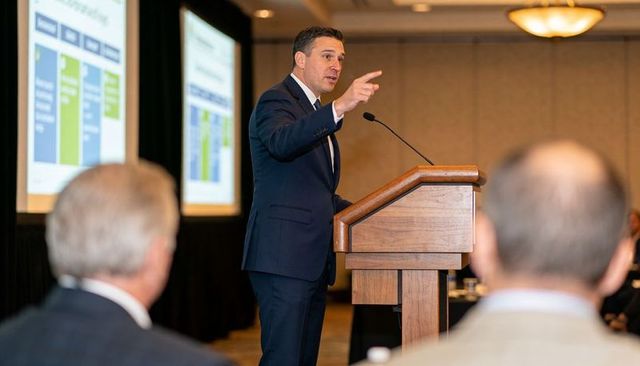 Confident business leader delivering keynote presentation to executive audience