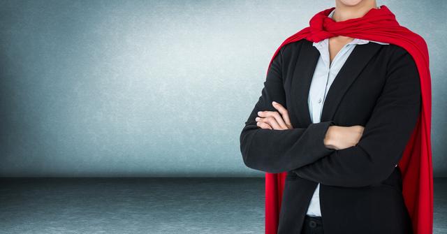 A businesswoman wearing a suit and red cape, standing with arms folded exuding confidence. Ideal for themes of leadership, empowerment, and professional success. Can be used for business presentations, motivational speaking engagements, and promotional materials for leadership training.