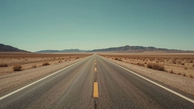 Endless desert highway with dramatic sky and distant mountains