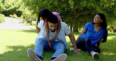 Family enjoying playful moments together in park setting