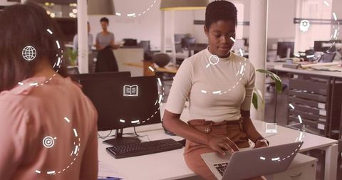 Focused female professional typing laptop in modern office