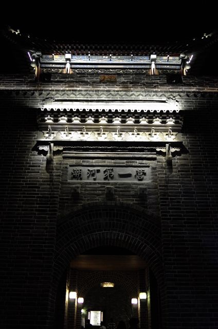 Traditional Chinese gate illuminated at night with lights. It showcases rich historical and architectural heritage. Suitable for use in topics involving Chinese culture, architecture, history, tourism promotion, and educational materials.