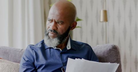 Concentrated man analyzing documents in comfortable home setting