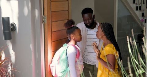 Loving family saying goodbye at home with warm hug