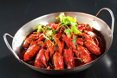 Spicy crawfish with fresh cilantro in steel pan