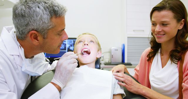 Dentist examining young patient with dental tool at dental clinic 4k