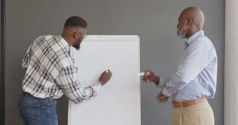 Business Professionals Discussing Graph Strategy on Whiteboard in Office