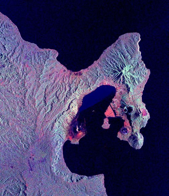Captured nearly a month after the significant eruption of the Rabaul volcano, this radar image shows color-coded terrains stressed by volcanic ash and pumice. Visible are volcanic vents like Vulcan and Tavurvur within the caldera forming Blanche Bay. Ash and pumice floating on the bay are evidenced among various geographic features in the southwest Pacific. Useful for geologists, environmental scientists, city planners, and educators examining the effects of natural disasters and improving hazard preparedness plans.
