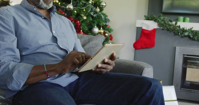 Senior african american man using tablet at christmas. Spending quality time at christmas and retirement concept.