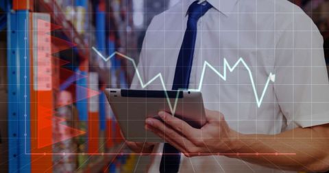 Businessman Analyzing Financial Trends on Tablet in Warehouse Environment