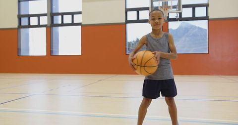 Young Boy Smiling Holding Basketball in School Gymnasium - Download Free Stock Images Pikwizard.com