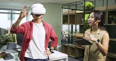 Coworkers Demonstrating Virtual Reality in Modern Office