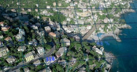 Aerial coastal village unfolding along hillside with railway, beach and digital grid overlay