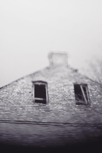Depicts an eerie, abandoned house with broken windows in a black and white tone. Useful for themes related to haunted houses, Halloween, decay, and spooky atmospheres. Can be used in articles about urban exploration, history of old buildings, or as a visual in mystery and horror themed projects.