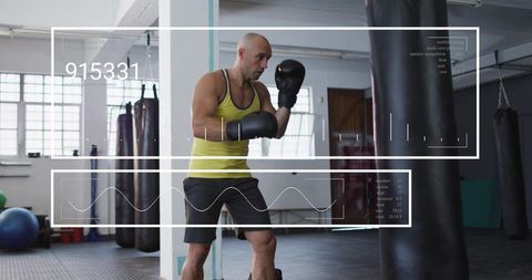 Boxer training with heavy bag, adjusting gloves in daylight gym for fitness conditioning