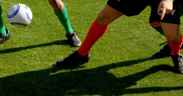 Legs of diverse football players playing on field with copy space. Football, sports, competition and team concept, unaltered.