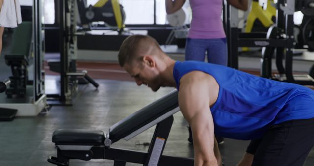 Man focuses on rowing exercises in a modern gym, strengthening back and arm muscles. Ideal for promotions in fitness programs, gym membership marketing, exercise tutorial content, health blogs, and motivational fitness visuals.