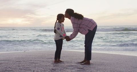 Mother and Daughter Sharing Love on Scenic Beach at Sunset