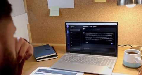 Businessman working on laptop at organized desk with reports