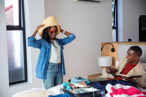 Couple Packing Suitcase Together for Vacation Preparation