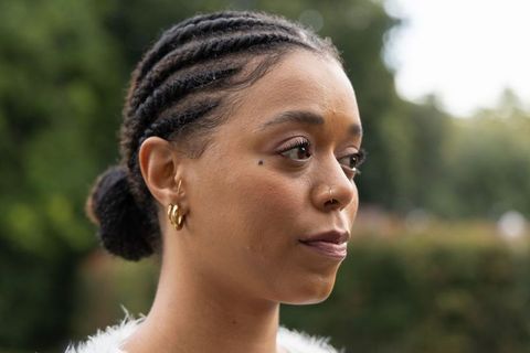African american woman wearing cornrow braids and gold hoops gazing right in park