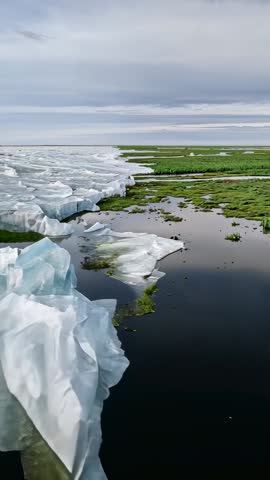 Fracturing Sea Ice Retreating into Coastal Marsh Vertical Drone Footage Showing Melting