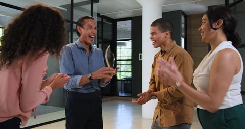 Diverse team celebrating success while rewarding best employee